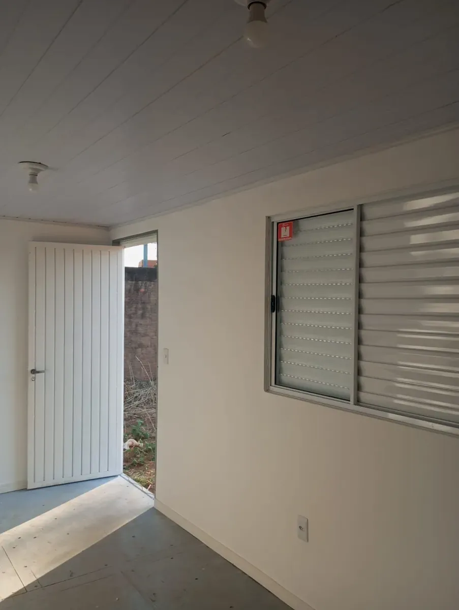 Interior do container escritório com porta e janela veneziana